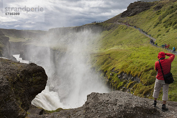 Tourist am Rande des Gullfoss Wasserfalls  Island