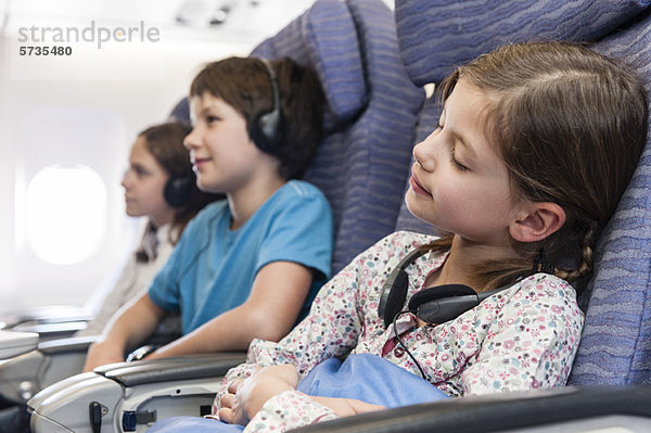 Mädchen schläft im Flugzeug