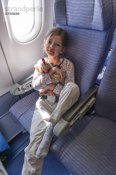 Mädchen mit Plüschtier im Flugzeug  Portrait