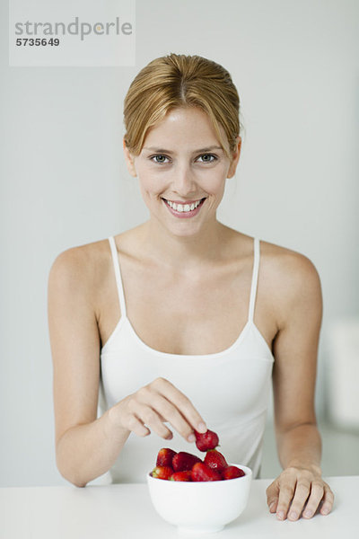 Junge Frau mit Erdbeerenschale