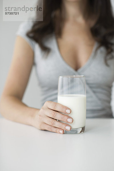 Frau hält ein Glas Milch in der Hand