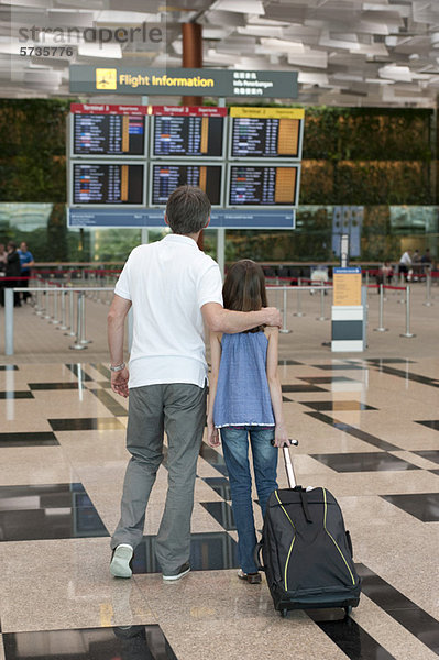 Vater und Tochter bei der Ankunft am Abflugbrett im Flughafen
