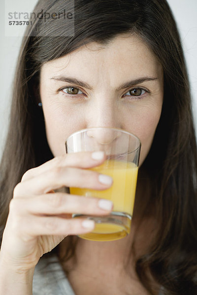Mittlere Erwachsene Frau trinkt Orangensaft