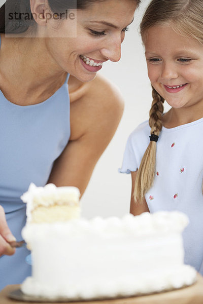 Mutter und Tochter beim Kuchenschneiden