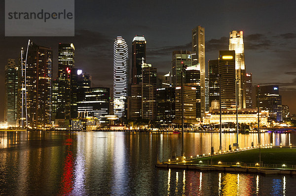 Die Skyline von Singapur bei Nacht von der Promenade aus gesehen