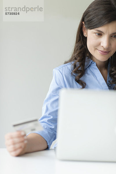 Mid-Erwachsene Frau mit Kreditkarte während der Nutzung des Laptops