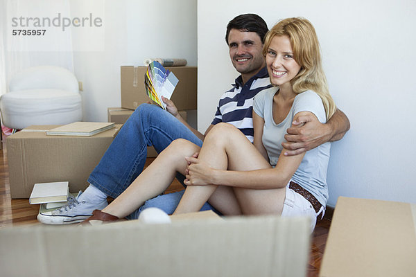 Paar auspacken im neuen Haus  Mann mit Farbmustern
