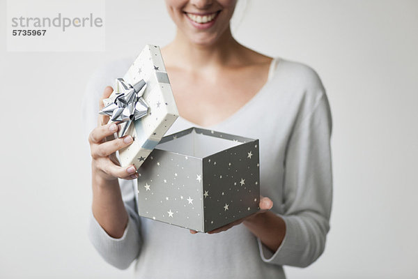 Frau öffnet Geschenkschachtel  beschnitten