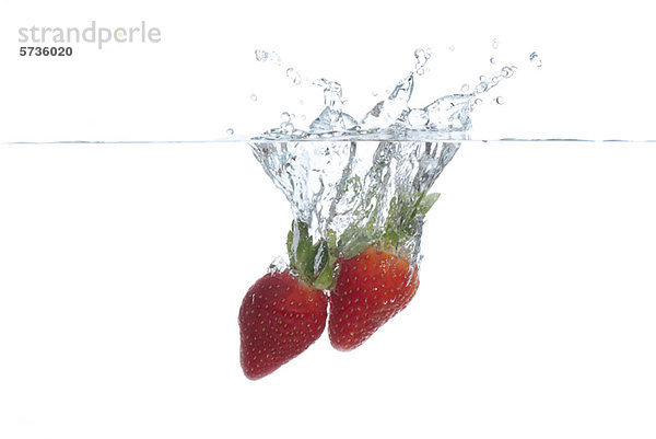 Erdbeeren  die ins Wasser spritzen