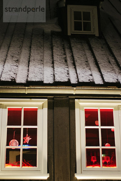 Weihnachtsschmuck hängt nachts im Fenster des Hauses