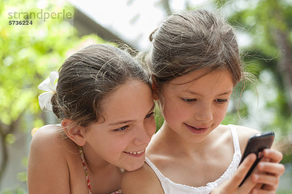 Schwestern schauen gemeinsam aufs Handy
