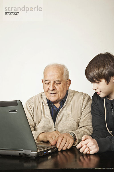 Senior und Junge am Laptop