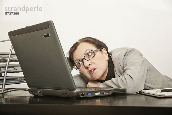 Frau im Büro vor Laptop  Burnout