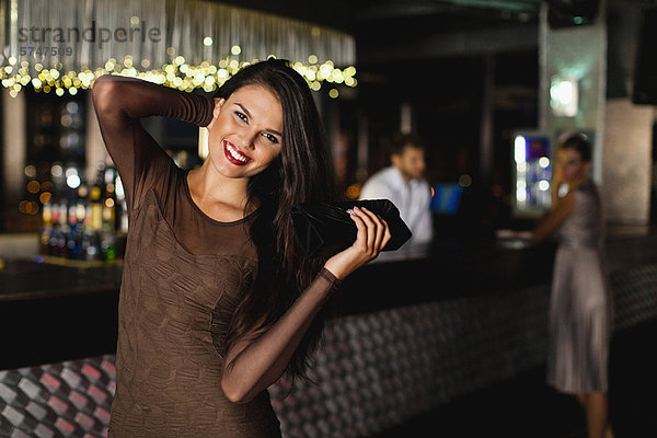 Lächelnde Frau in der Bar stehend