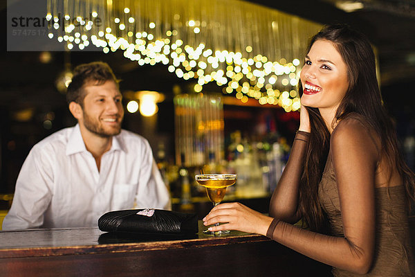 Frau im Gespräch mit Barkeeper an der Bar