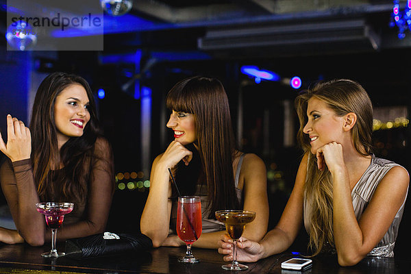 Frauen bei gemeinsamen Drinks an der Bar