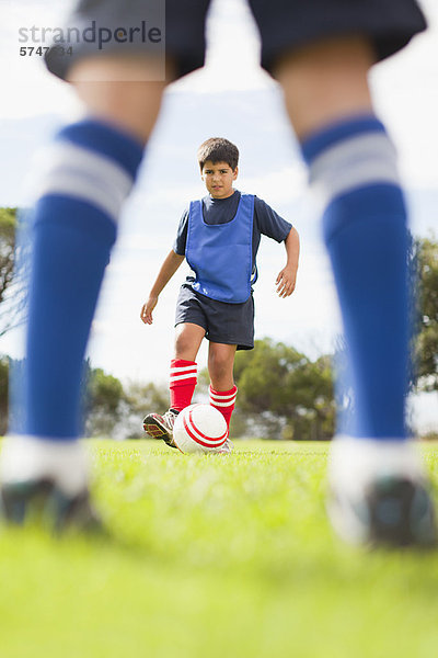 Jungen spielen Fußball auf dem Spielfeld