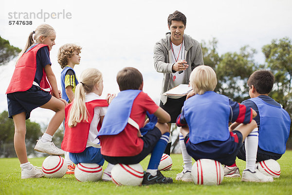 Trainer im Gespräch mit der Kinderfußballmannschaft