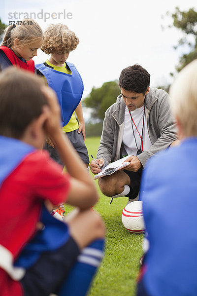 Trainer im Gespräch mit der Kinderfußballmannschaft