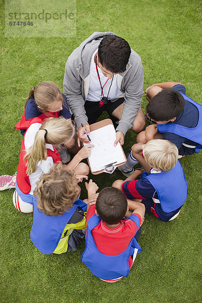 Trainer im Gespräch mit der Kinderfußballmannschaft