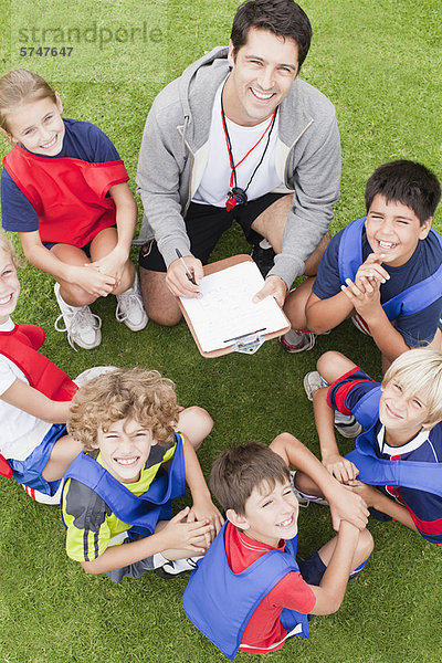 Trainer im Gespräch mit der Kinderfußballmannschaft