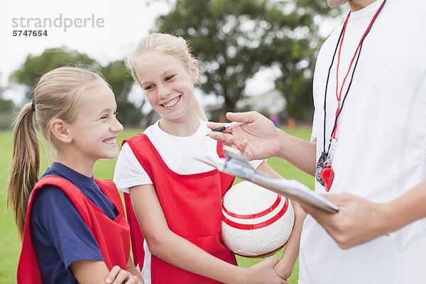 Trainer im Gespräch mit Kindern der Fußballmannschaft