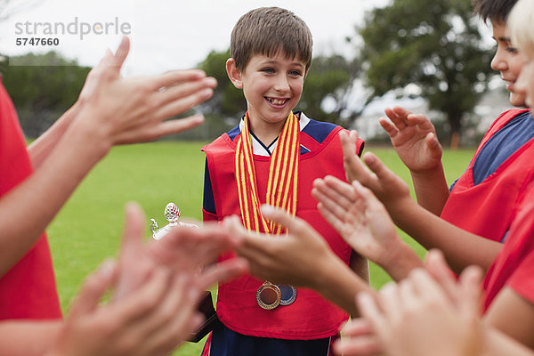 Kinderjubelnder Teamkollege mit Trophäe