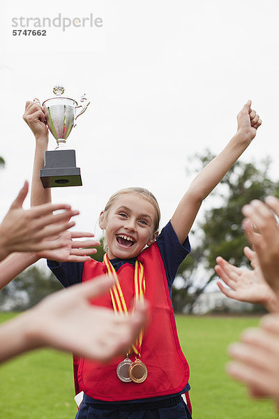 Kinderjubelnder Teamkollege mit Trophäe