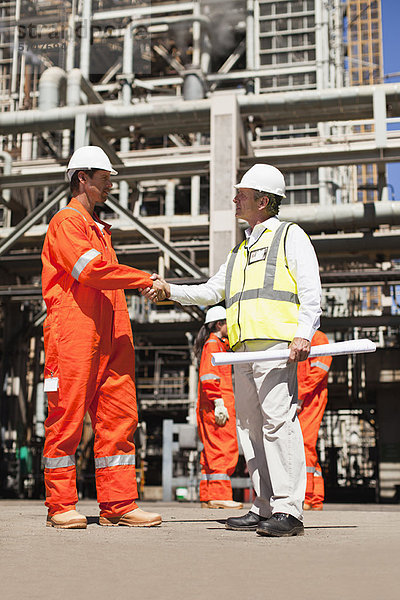 Arbeiter beim Händeschütteln in der Ölraffinerie
