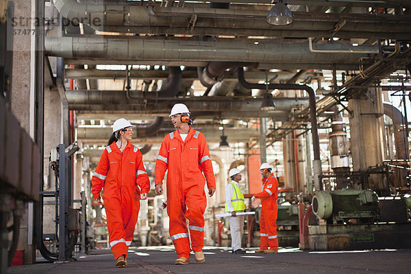 Arbeiter  die in der Ölraffinerie spazieren gehen