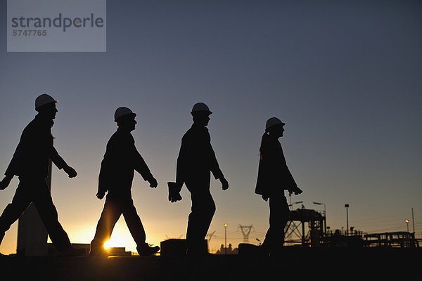 Silhouette der Arbeiter in der Ölraffinerie