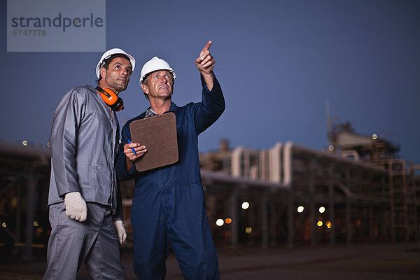 Arbeiter im Gespräch in der Ölraffinerie