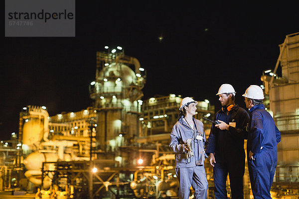 Arbeiter im Gespräch in der Ölraffinerie