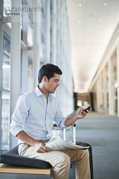 Geschäftsmann mit Handy in der Lobby