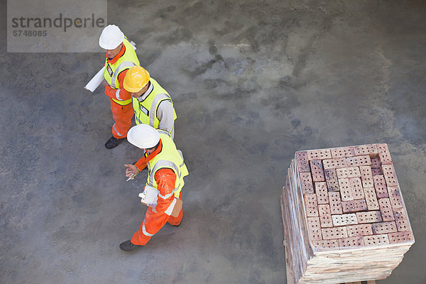 Arbeiter  die auf der Baustelle laufen