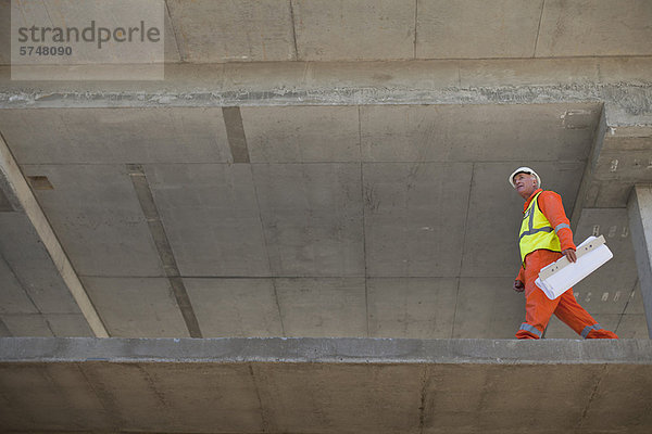 Arbeiter mit Bauplänen vor Ort