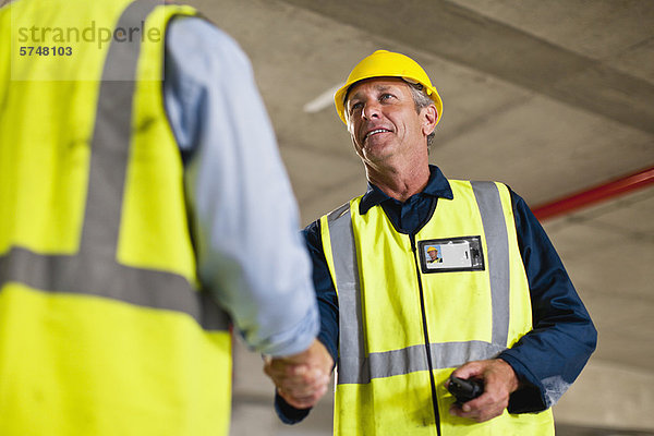 Arbeiter beim Händeschütteln vor Ort