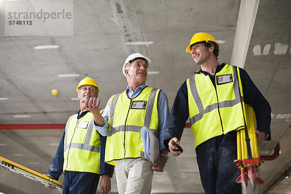 Arbeiter  die auf der Baustelle laufen