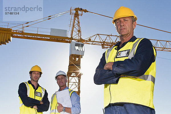 Arbeiter  die auf der Baustelle stehen