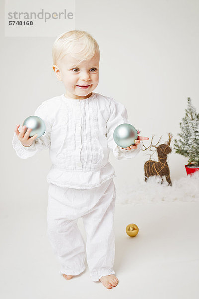 Baby Mädchen mit Weihnachtsschmuck