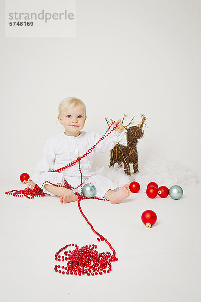 Baby Mädchen mit Weihnachtsschmuck