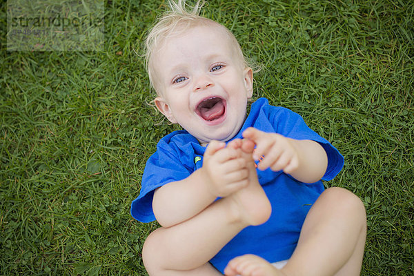 Baby Junge spielt mit seinen Füßen