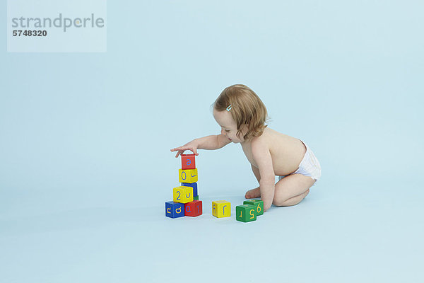 Kleines Mädchen spielt mit bunten Blöcken