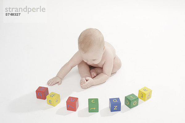 Baby Boy spielt mit farbigen Blöcken