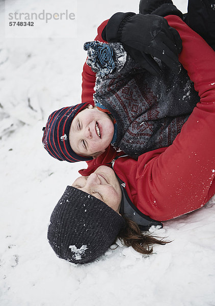 Mutter und Sohn spielen im Schnee