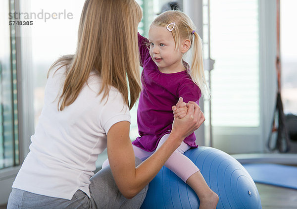 Mädchen spielen mit Übungsball in der Turnhalle