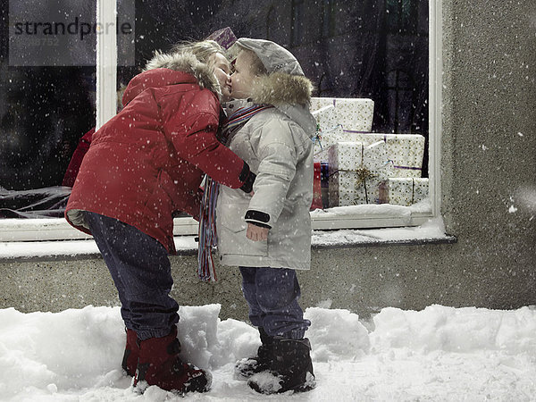 Kinder küssen sich im Schnee