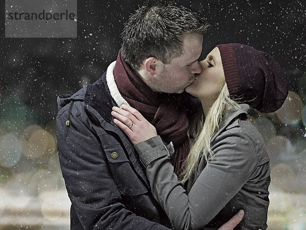 Paar Küssen im Schnee bei Nacht