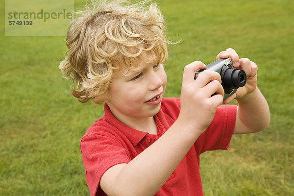 Junge beim Fotografieren im Freien