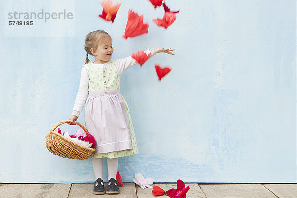 Lächelndes Mädchen spielt mit Papierblumen
